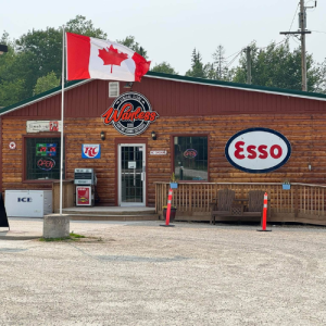 The exterior of the store has a vintage log cabin look with old metal signs