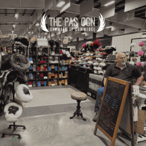 Booth at a trade show selling fur hats and hand-made leather goods.