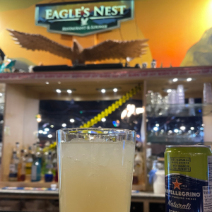 Refreshing beverage at the lounge bar with logo and eagle carved art in background