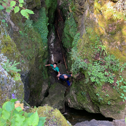 two boys looking up from in the crevace of the caves