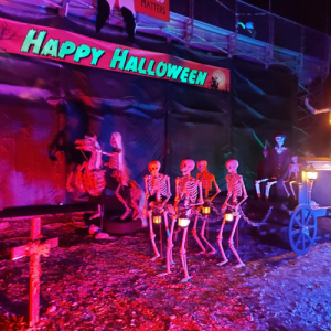 skeletons pulling a carriage at night with Halloween decorations