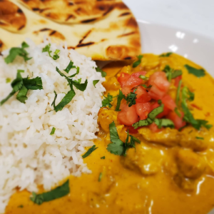 close up image of basmati rice, butter chicken and naan bread