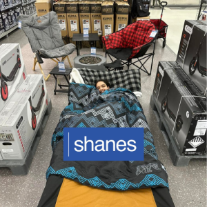 smiling person napping on cot inside the store