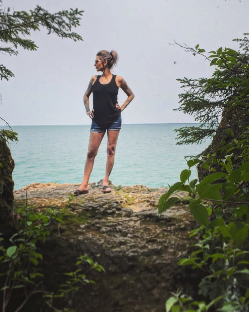 Angel posing at The Caves with the green clear water of Clearwater Lake in the background