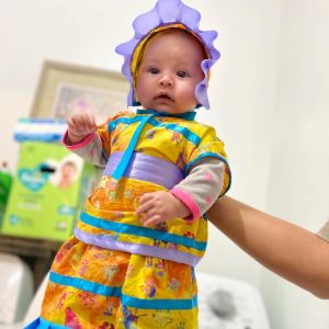 infant wearing regalia and bonnet