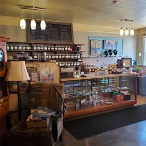 interior front ordering section of café, with tea selection, artwork and other gifts they have for sale on display