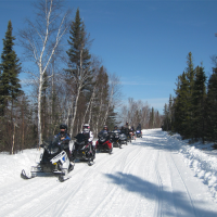 Line of snowmobiles on a trail