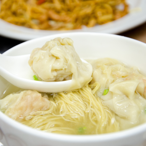 wonton soup with udon noodles in the background